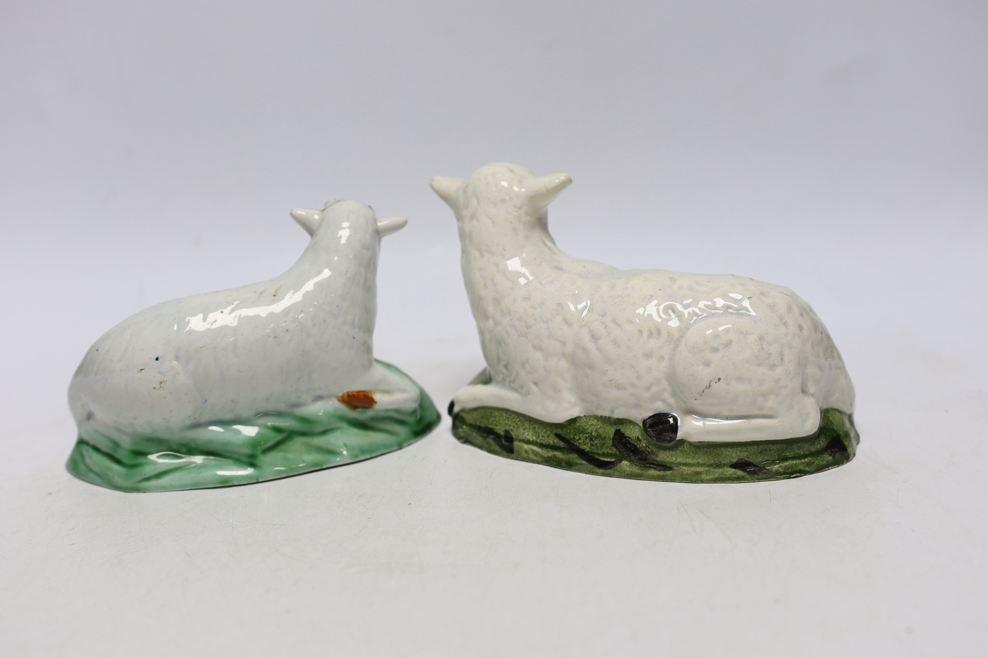 Two late 18th/early 19th century Staffordshire pottery models of recumbent sheep, 16cm wide
